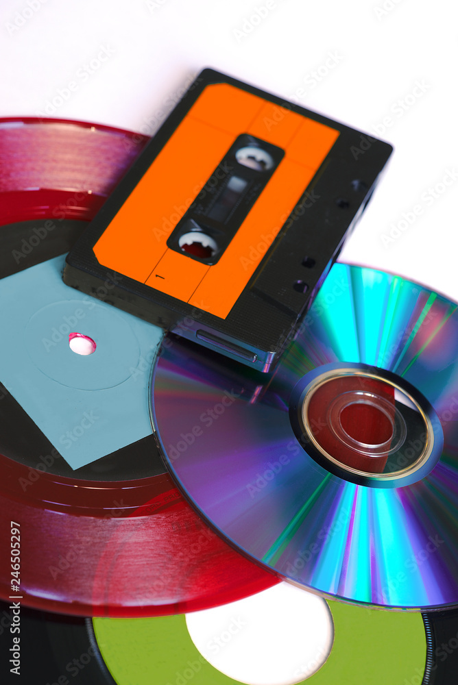 CD, disque vinyle rouge et noir et cassette audio sur fond blanc CD, disque vinyle rouge et noir et cassette audio sur fond blanc
