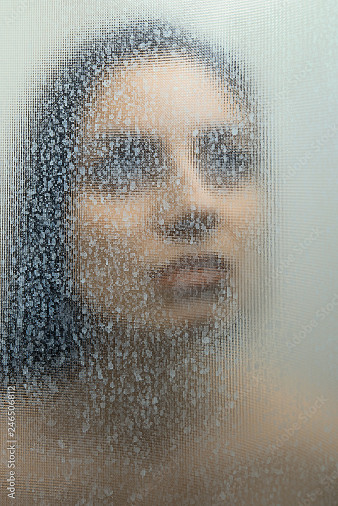 Girl  behind a foggy glass
