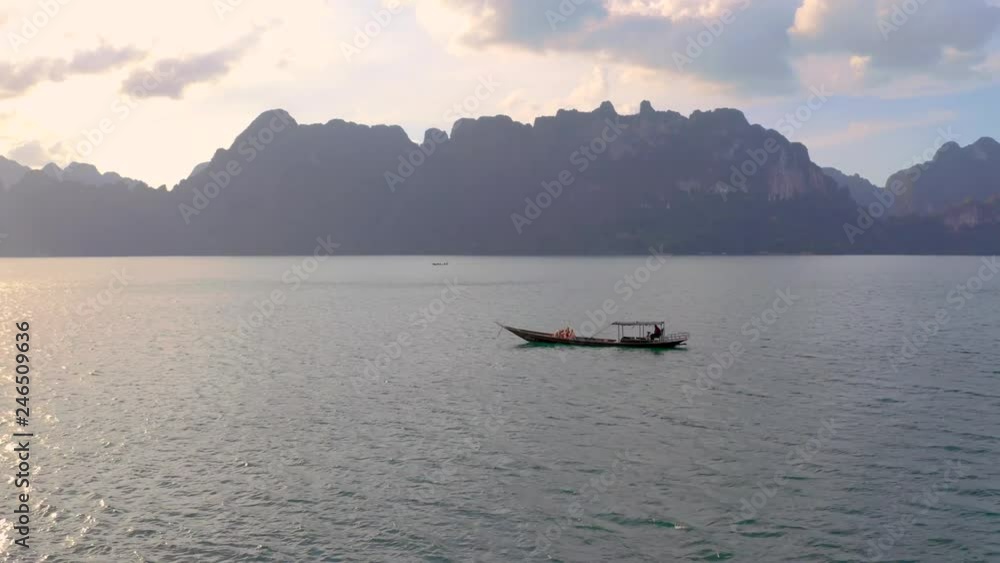 Aerial view of beautiful natural attractions.Small boat crossing Cheow Lan Lake,Khao Sok National Park,Surat Thani Province,Thailand.Power of nature,wanderlust and amazing destination concept Aerial view of beautiful natural attractions.Small boat crossing Cheow Lan Lake,Khao Sok National Park,Surat Thani Province,Thailand.Power of nature,wanderlust and amazing destination concept