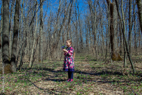 Portrait of a beautiful little girl with corydalis flowers.