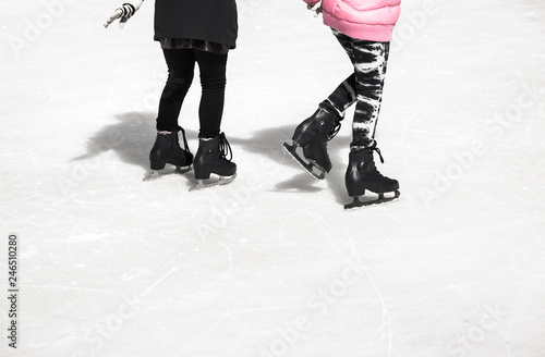 Two teenage girl friends skating on ice.