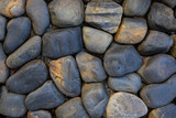 Round stone paving. Natural stone masonry top view. Seaside pebble photo texture. Stone wall surface.