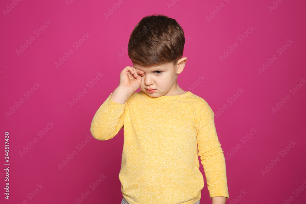 Little boy rubbing eye on color background. Annoying itch Little boy rubbing eye on color background. Annoying itch