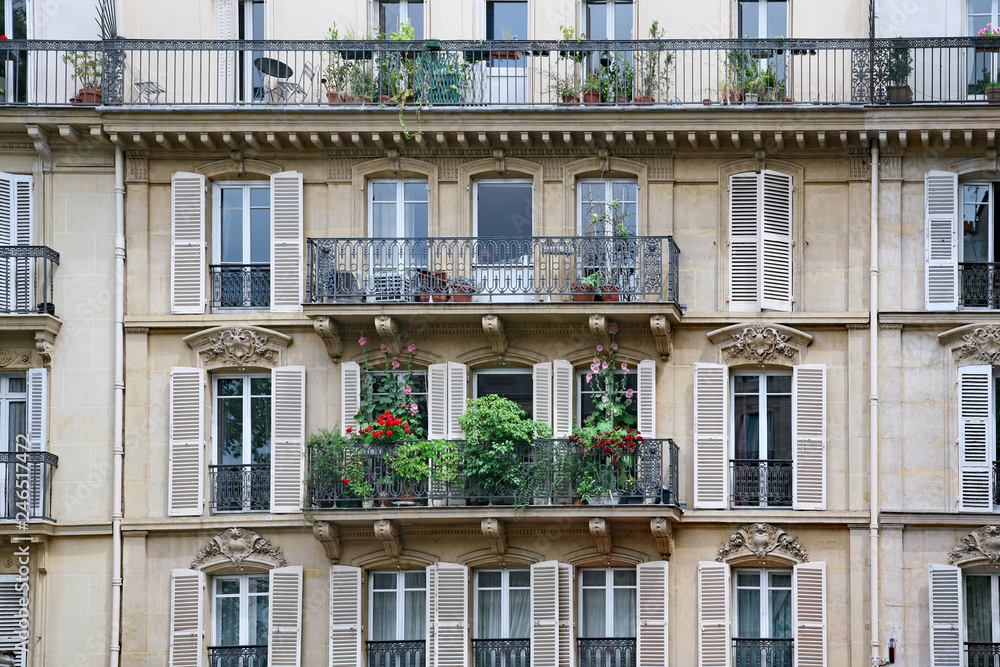 facade and balcony of apartment building with ornate 19th century architecture typical of  central Paris