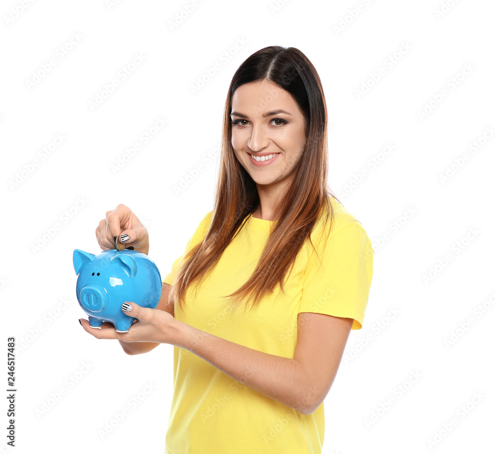 Young woman putting coin into piggy bank on white background Young woman putting coin into piggy bank on white background