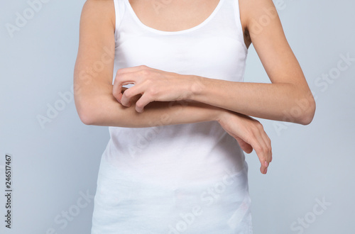 Wallpaper Mural Young woman scratching arm on light background, closeup. Annoying itch Torontodigital.ca
