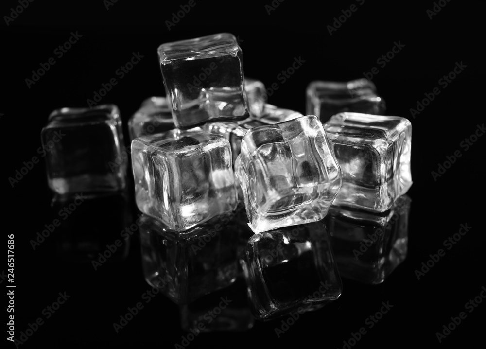 Pile of crystal clear ice cubes on black background