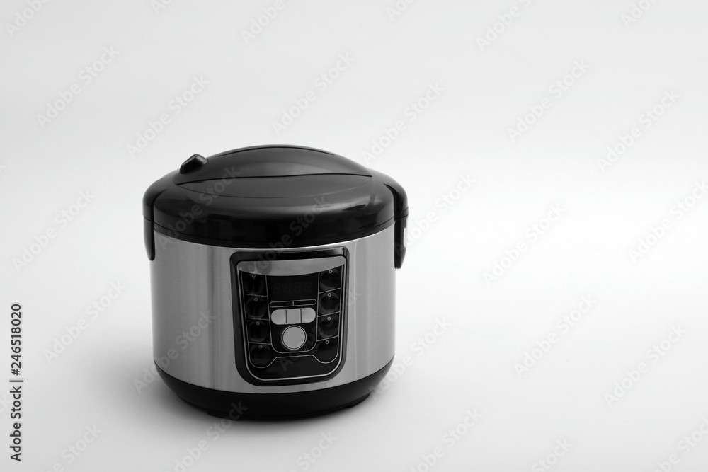 Modern electric multi cooker on light background. Space for text Modern electric multi cooker on light background. Space for text