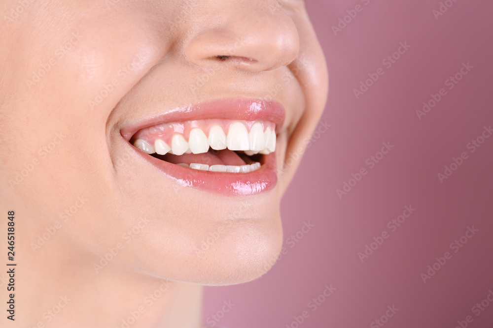 Obraz premium Young woman with healthy teeth and beautiful smile on color background, closeup. Space for text