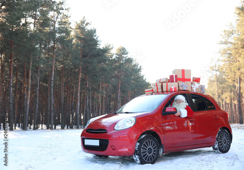 Authentic Santa Claus in red car with gift boxes, view from outside © New Africa