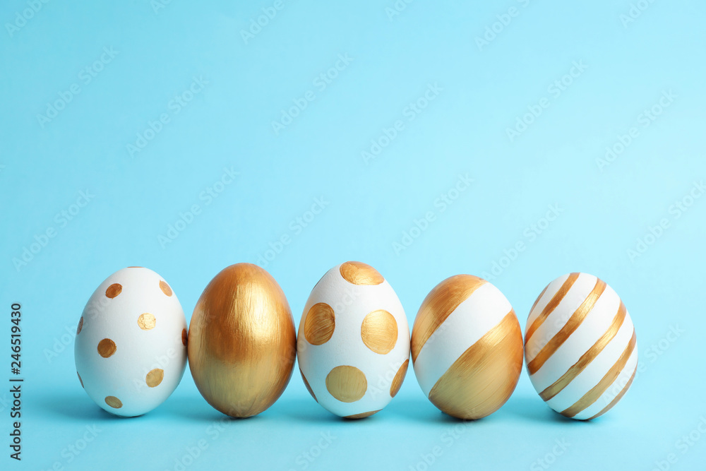 Line of traditional Easter eggs decorated with golden paint on color background