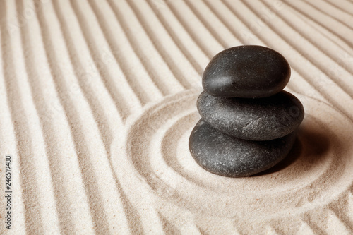 Stacked zen garden stones on sand with pattern  space for text. Meditation and harmony