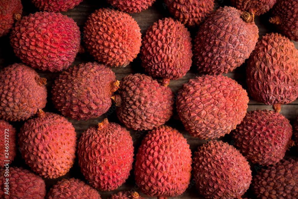 Red ripe lychees on the rustic background. Selective focus. Shallow depth of field.