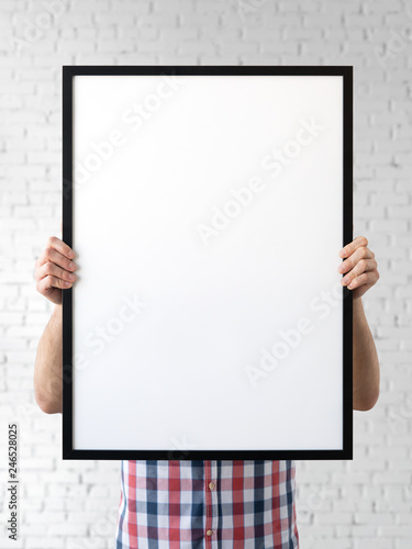 Holding frame mockup. Photo Mockup. The man hold frame. For frames and posters design. Frame size 20x28 (50x70cm).