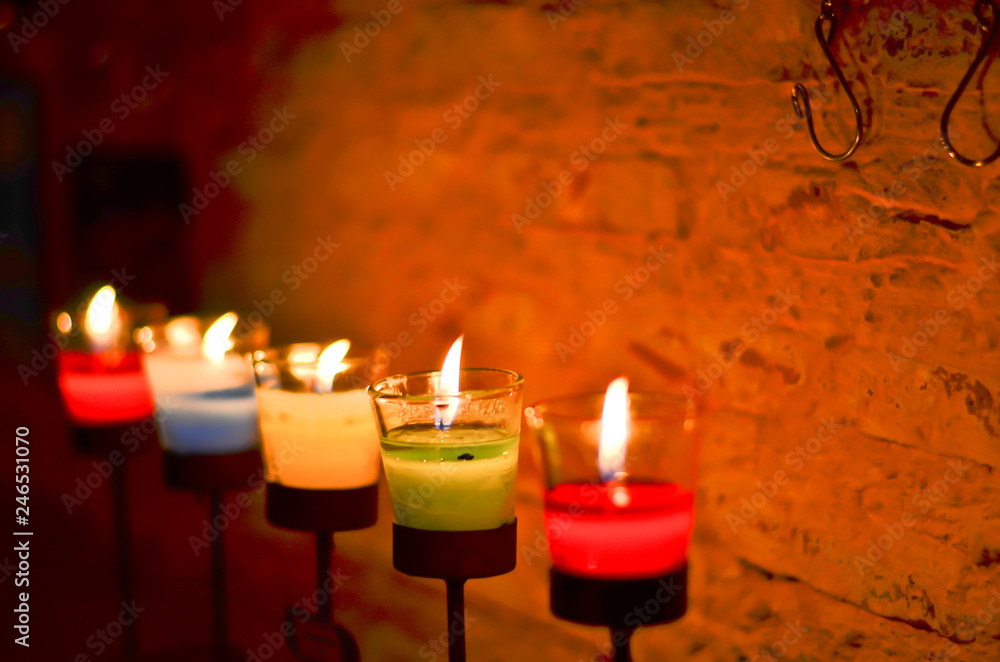 Many candles burning at night, shallow depth of field, wall background Many candles burning at night, shallow depth of field, wall background