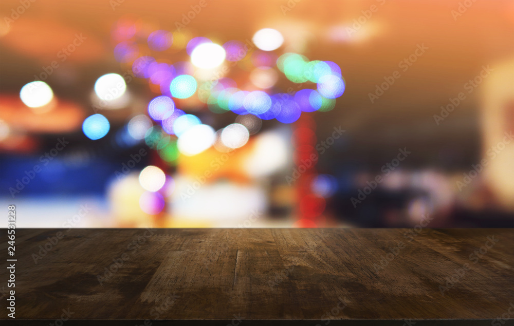 Empty dark wooden table in front of abstract blurred bokeh background of restaurant . can be used for display or montage your products.Mock up for space.