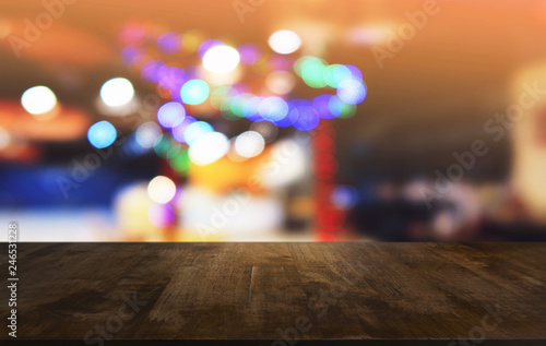 Empty dark wooden table in front of abstract blurred bokeh background of restaurant . can be used for display or montage your products.Mock up for space.