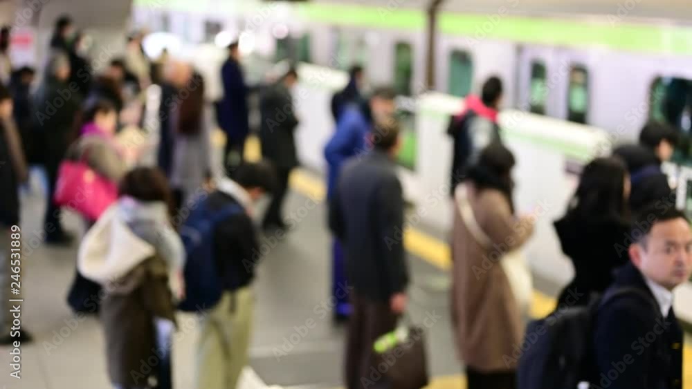 ホームに到着する電車と、それに乗り込む人々。 ホームに到着する電車と、それに乗り込む人々。