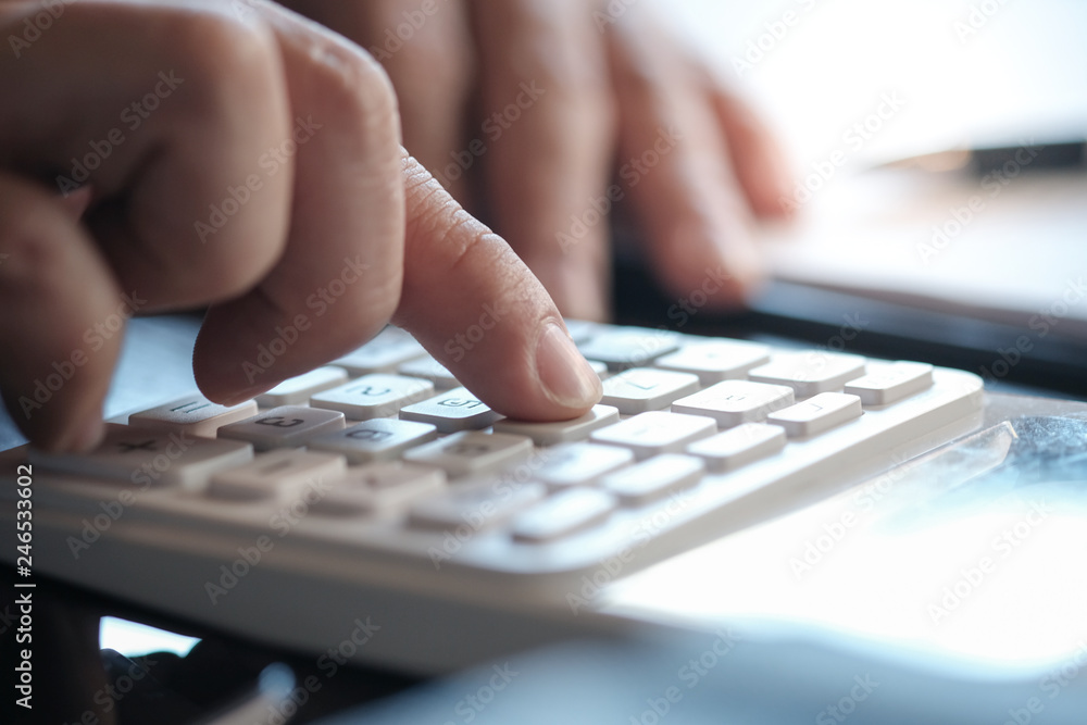 Businessman analyzing investment charts and pressing calculator buttons over documents. Accounting Concept. Businessman analyzing investment charts and pressing calculator buttons over documents. Accounting Concept.