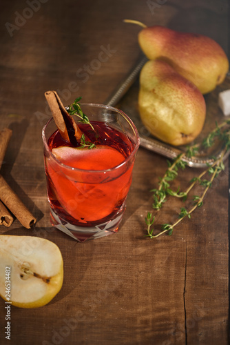 homemade hot mulled pear cider with a cinnamon stick on a wooden background