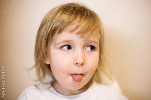 cute smiling little child girl face closeup portrait with tongue out