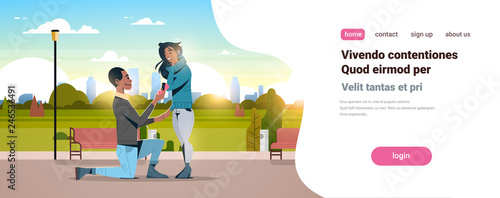 man kneeling holding engagement ring proposing woman marry him happy valentines day concept city park cityscape african american couple in love marriage offer copy space
