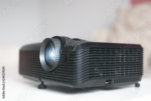 Black projector on a table. Home movie theatre concept background.
