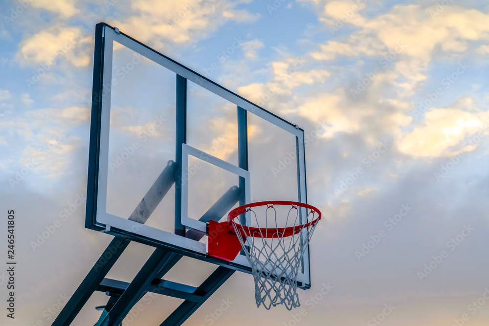 Basketball basket and board against a cloudy sky