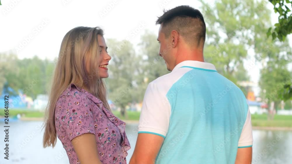 A young couple, the family spends the weekend in the park. They are pleasantly talking, happy together. A young couple, the family spends the weekend in the park. They are pleasantly talking, happy together.