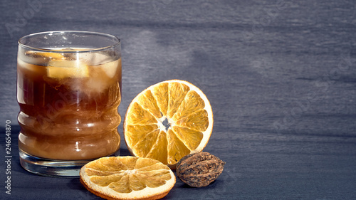 Drink with ice in a stanie on a dark background and oranges. photo