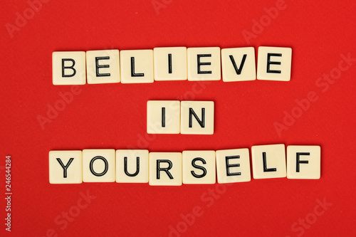 Inspirational sentence Believe in yourself formed with game tiles