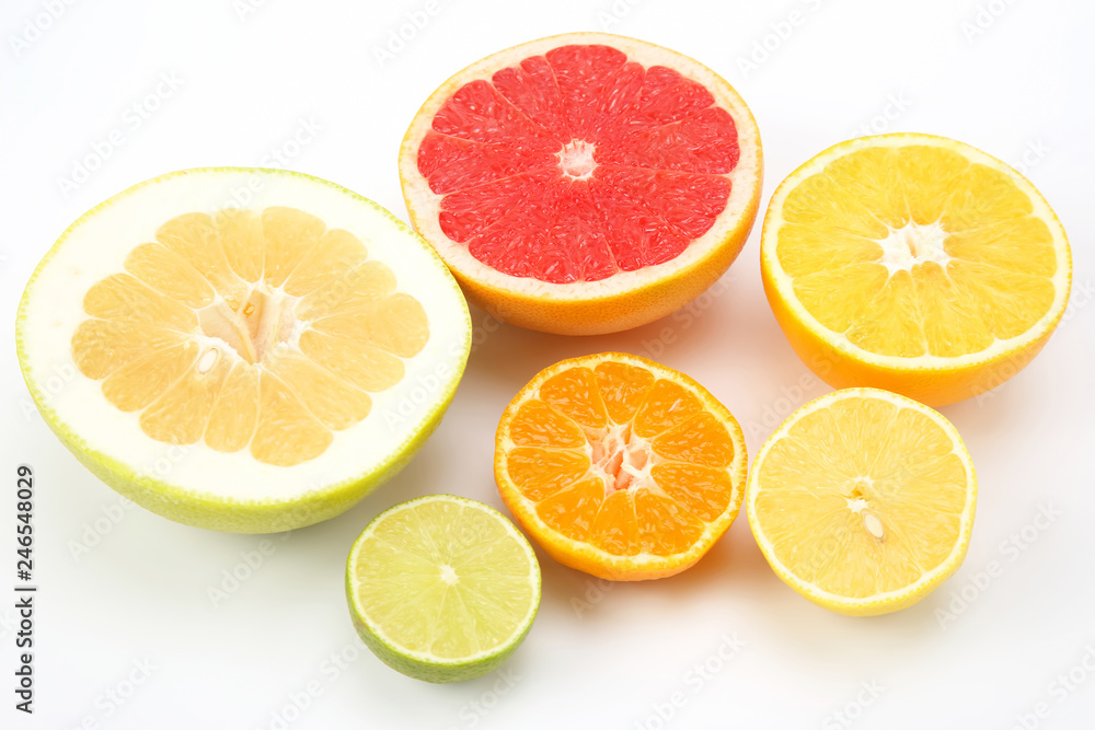 cut pieces of different citrus fruits on white background