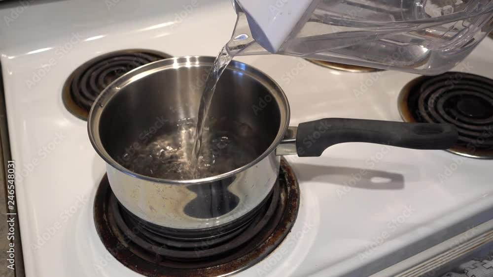 4K Water Being Poured From Container Into Pot To Boil 4K Water Being Poured From Container Into Pot To Boil