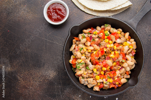 Preparation of filling for burritos in tortillas with meat, vegetables, white beans, red pepper, corn. Delicious lunch, Mexican food, homemade snack