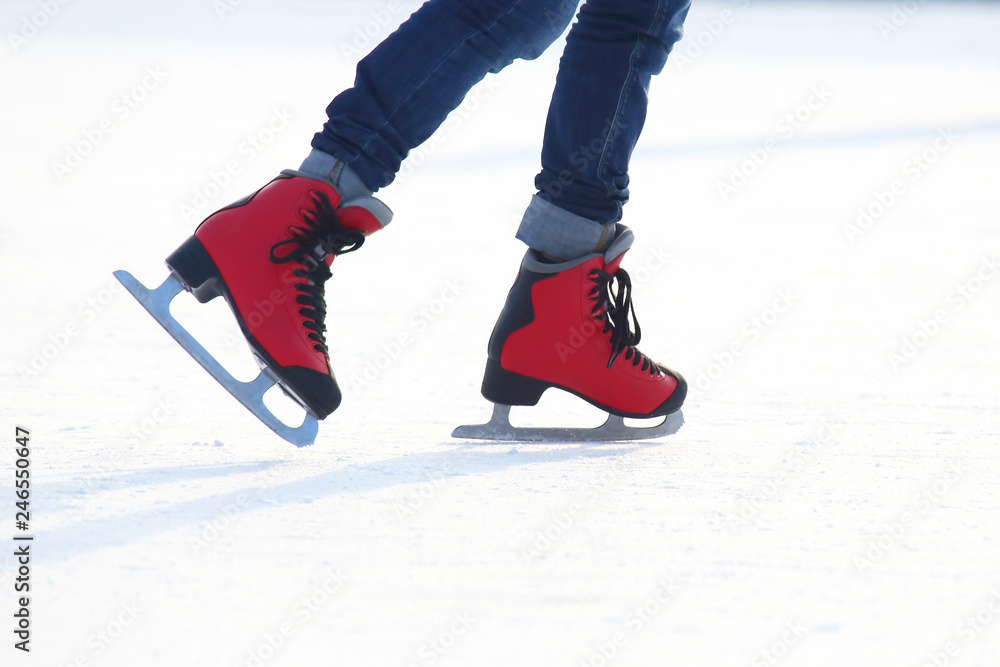Female legs in skates on an ice rink Female legs in skates on an ice rink