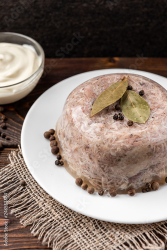 Jellied aspic with chicken meat, traditional Russian dish holodets on dark wooden background. photo