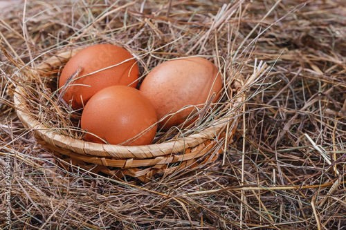 Easter composition. Several eggs in a wicker basket on hay