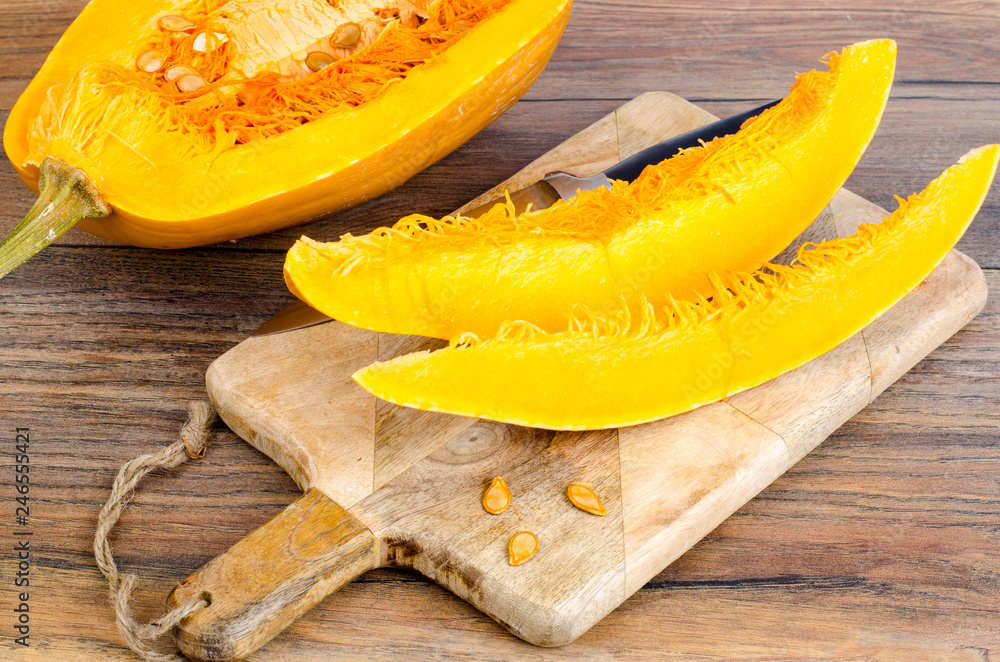 Sliced ripe pumpkin on wooden table Sliced ripe pumpkin on wooden table