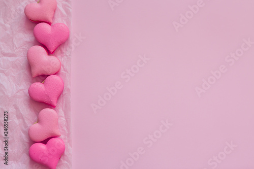 macaroons in the form of hearts on pink backdrop of.heart-shaped macaroons on pink background.Macaroons Heart.Valentine's Day.Pink gift tied with rosy ribbon and macaron macaroon cookie on pink heart 