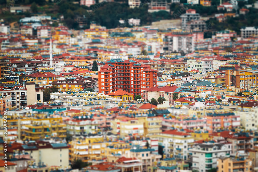 the roofs of different houses from the height of the birds flight. various buildings with cisterns and conditioners. aerial view of the city in blurred vignette