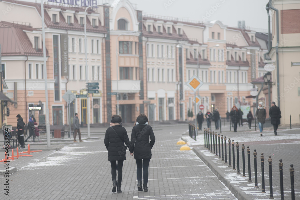 Two young women walk on the streets of Minsk holding hands