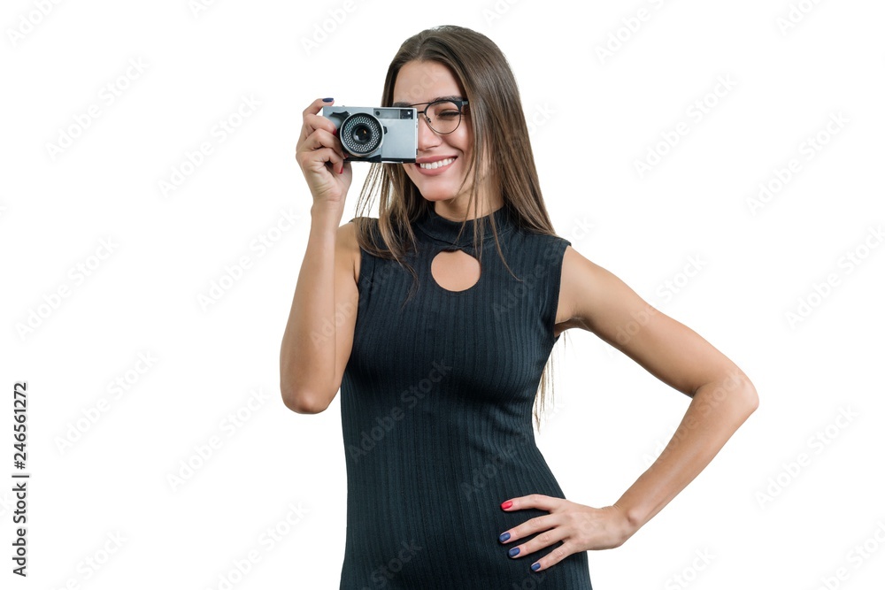 Young smiling beautiful woman in black dress glasses holding photo camera in her hands, taking photo, on white isolated background Young smiling beautiful woman in black dress glasses holding photo camera in her hands, taking photo, on white isolated background
