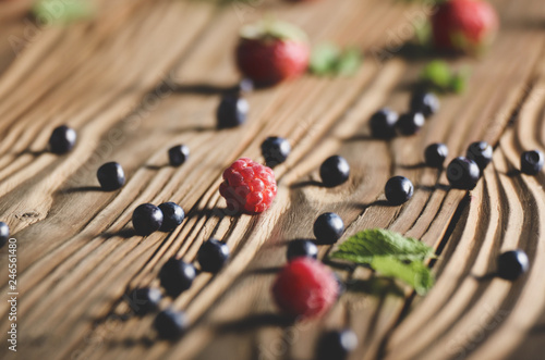 Ripe organic Raspberries and Blueberries on the top of wooden table