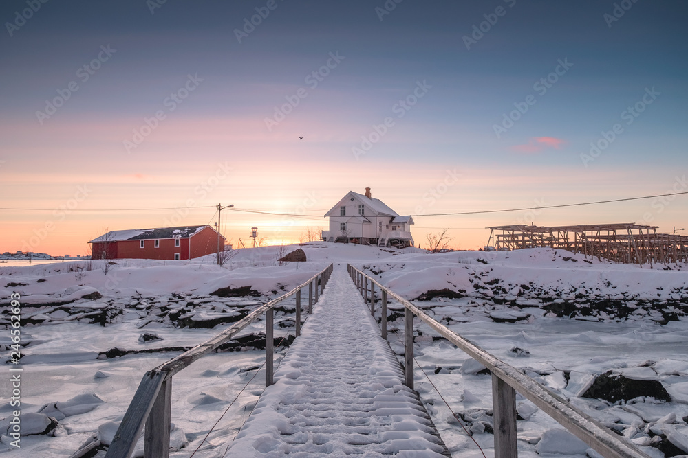 White house with wooden bridge and frozen coastline