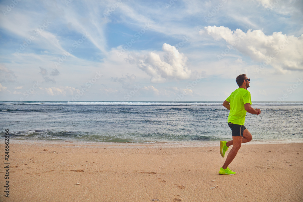 Man running / jogging on a tropical exotic beach.