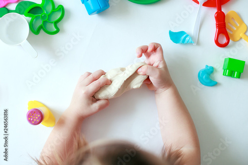 A Childs hands holding Play Dough. Concept of sensetive education and therapy of kids, top view