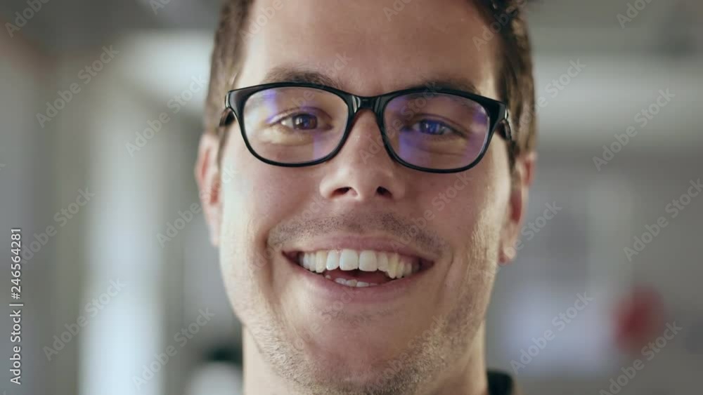 Close up of a young business man smiling confidently at the camera Close up of a young business man smiling confidently at the camera