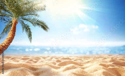 Summer background, nature of tropical beach with rays of sun light. Golden sand beach, palm tree, sea water against blue sky with white clouds. Copy space, summer vacation concept.