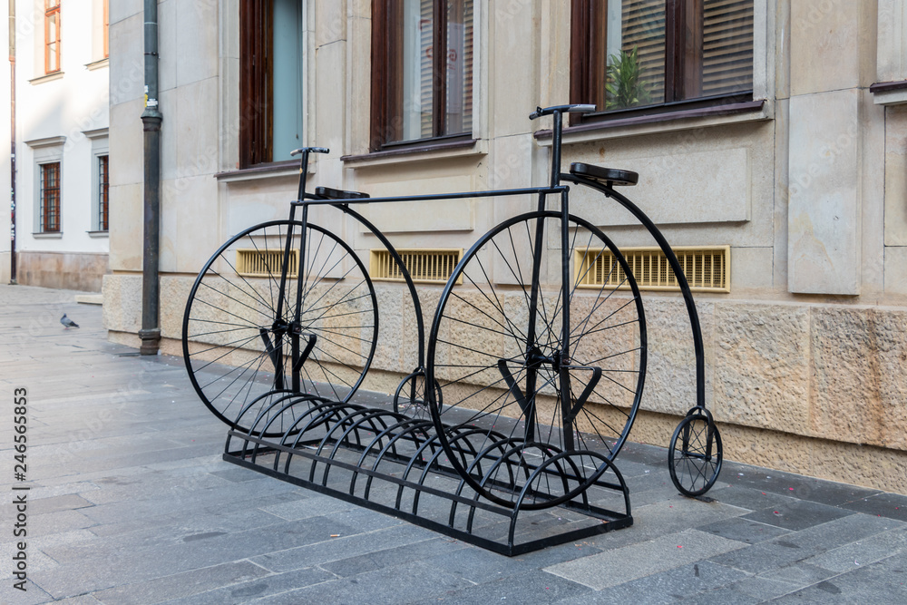 An empty bicycle rack with two old time big wheel bicycles in Bratislava