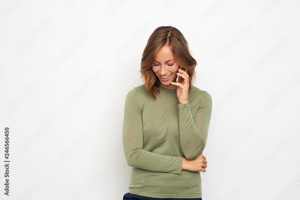 portrait of young smiling woman with mobile phone looking down portrait of young smiling woman with mobile phone looking down